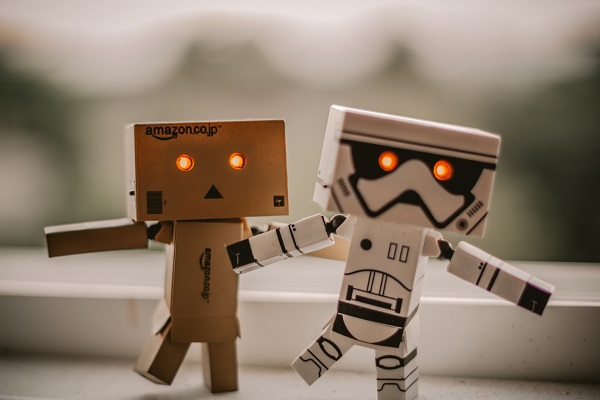 Two cardboard robots with red eyes.